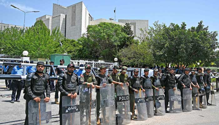 Security personnel stand guard as the supporters of parties from Pakistan´s ruling alliance gather near the Supreme Court in Islamabad on May 15, 2023. — AFP