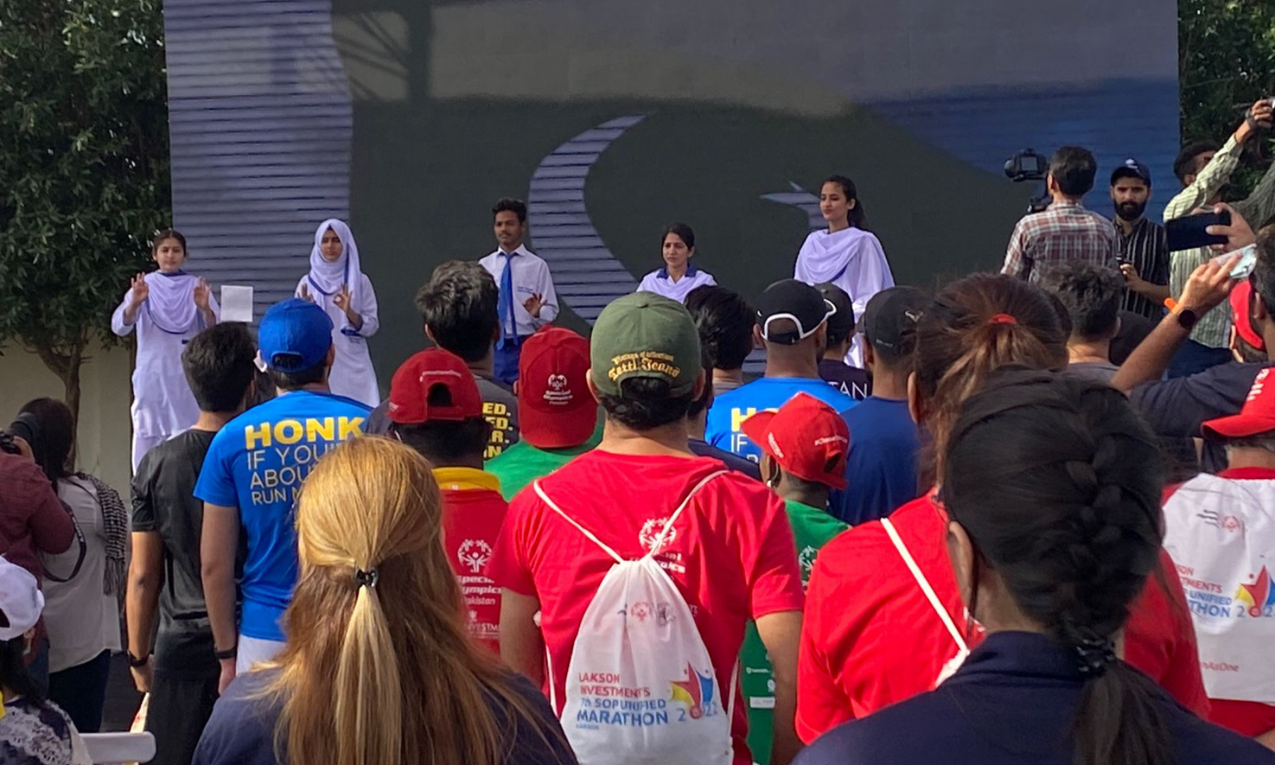 A group of kids perform the national anthem in sign language on the stage at the 7th SOP Unified Marathon.