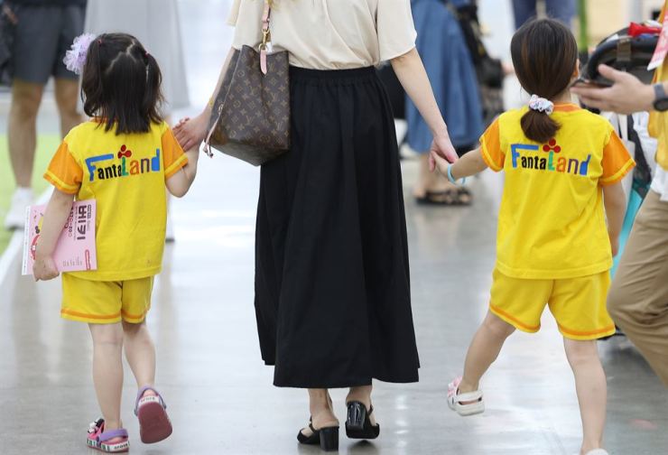 A mother walks with her children at an exhibition held in Daegu, Aug. 17. Yonhap