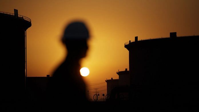 The sun sets beyond crude oil storage tanks at the Juaymah tank farm at Saudi Aramco's Ras Tanura oil refinery and oil terminal in Ras Tanura, Saudi Arabia, on Monday, Oct. 1, 2018. | Photographer: Simon Dawson | Bloomberg