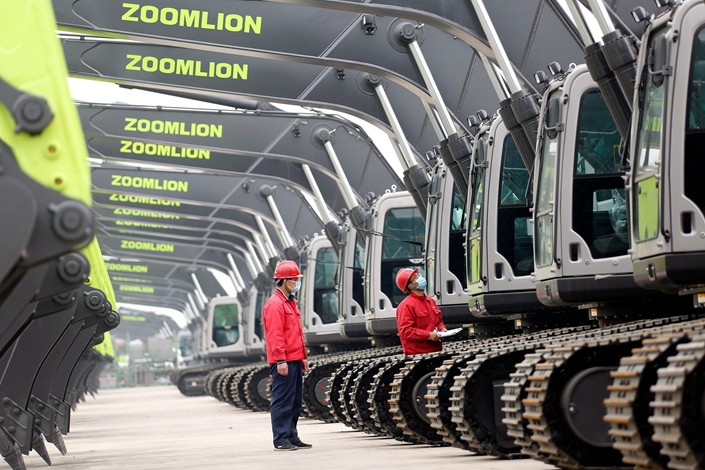 Inspectors examine an excavator before it leaves a Zoomlion factory in Weinan, Northwest China's Shaanxi province, on March 12.