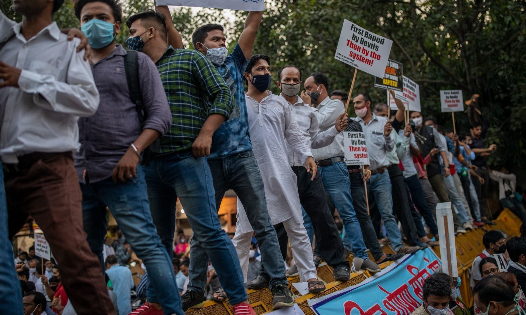 Protestors stand on a barricade and raise their voices against the gang rape and killing of a woman, in New Delhi, India, Friday. — AP