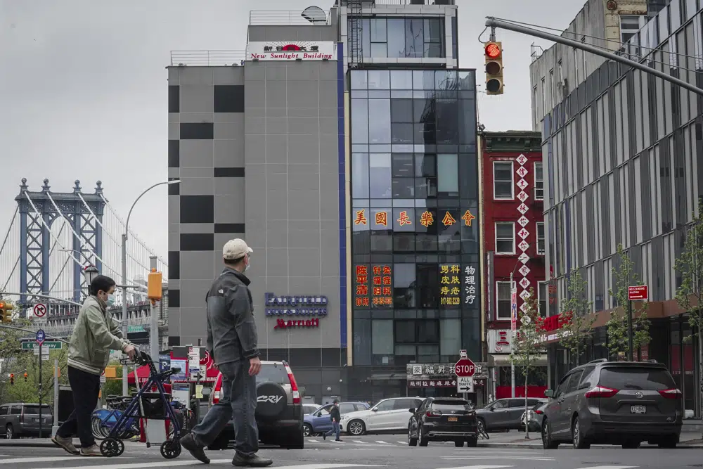 A six story glass facade building, center, is believed to be the site of a foreign police outpost for China in New York's Chinatown, Monday, April 17, 2023. Justice Department officials say two men have been arrested on charges that they helped establish a secret police outpost in New York City on behalf of the Chinese government. (AP Photo/Bebeto Matthews)