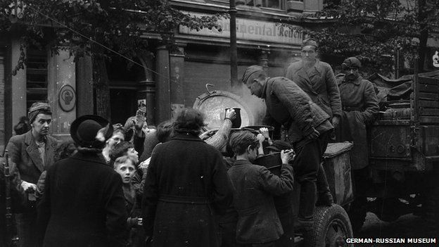 Soviet soldiers distribute food