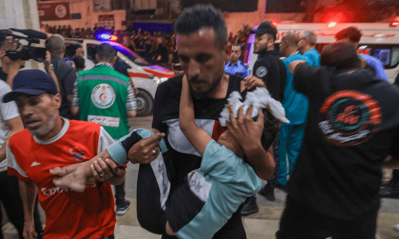  A Palestinian child injured in an Israeli air strike is carried inside the Nasser hospital in Khan Yunis in the southern of Gaza Strip, on October 17. — AFP 