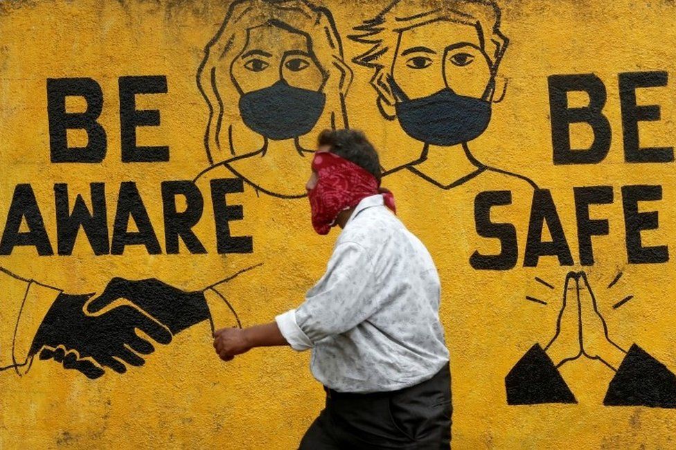 A man walks past a graffiti amid the spread of the coronavirus disease (COVID-19) in Mumbai, India, November 2, 2020.