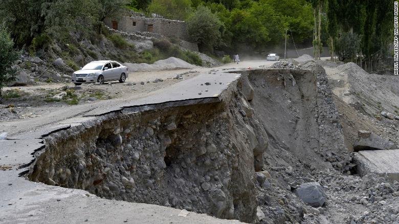 A vehicle drives past a partially collapsed section of Pakistan's Karakoram Highway damaged after a glacial lake outburst in the country's Gilgit-Baltistan region.