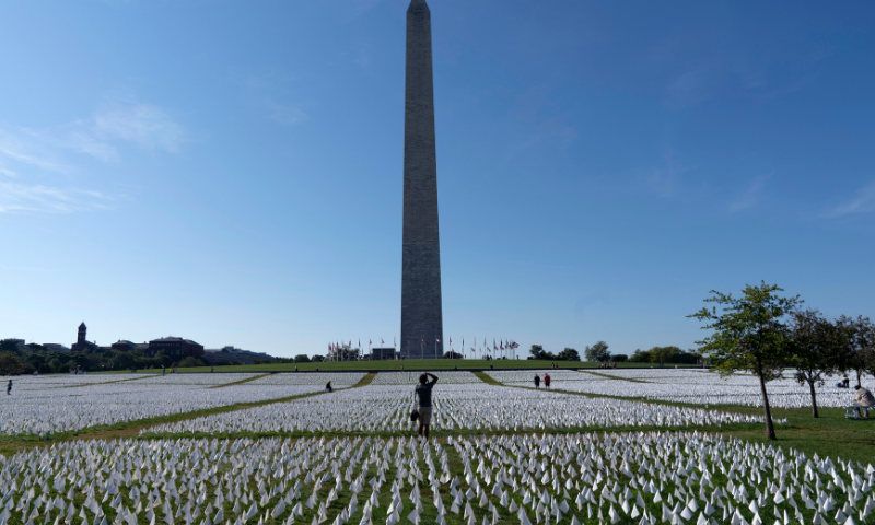 Visitors walks through artist Suzanne Brennan Firstenberg's “In America: Remember,” a temporary art installation made up of white flags to commemorate Americans who have died of Covid-19, on the National Mall, in Washington, on Saturday. — AP