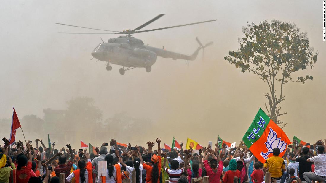 Supporters of Modi's Bharatiya Janata Party (BJP) wave towards a helicopter carrying the prime minister as he arrives at a rally on April 10. 