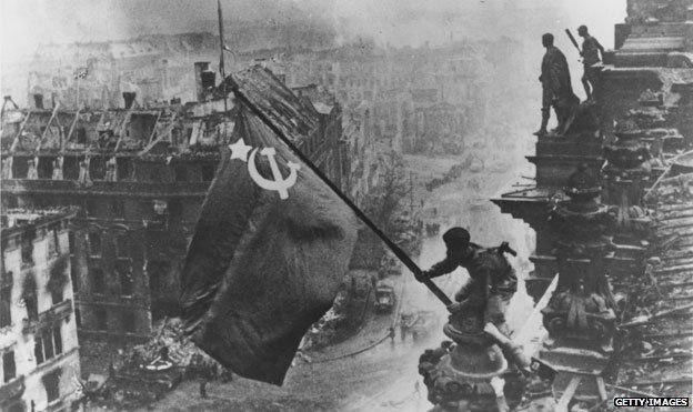 Red Army soldier raises the Soviet flag over the Reichstag in Berlin