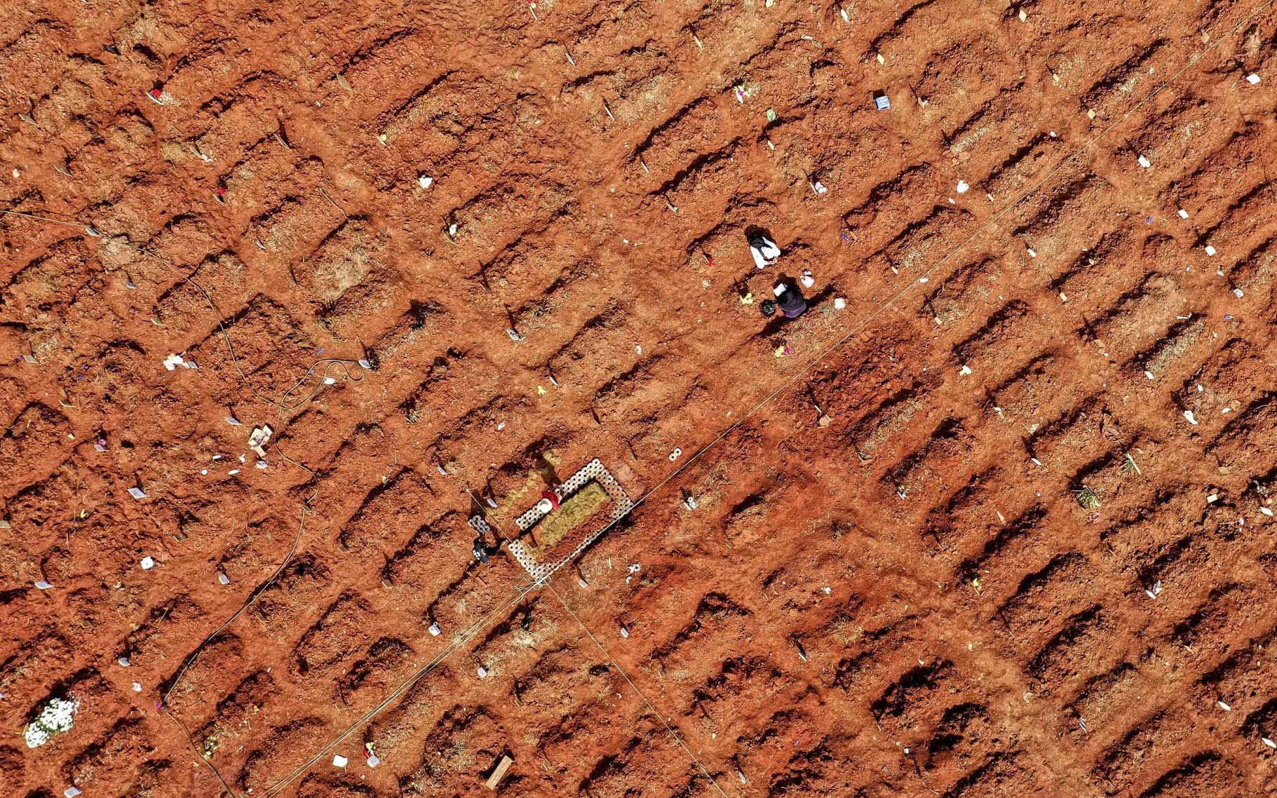 An aerial picture of family members at their relative's grave at the Pedurenan Covid-19 public cemetery in Bekasi, West Java