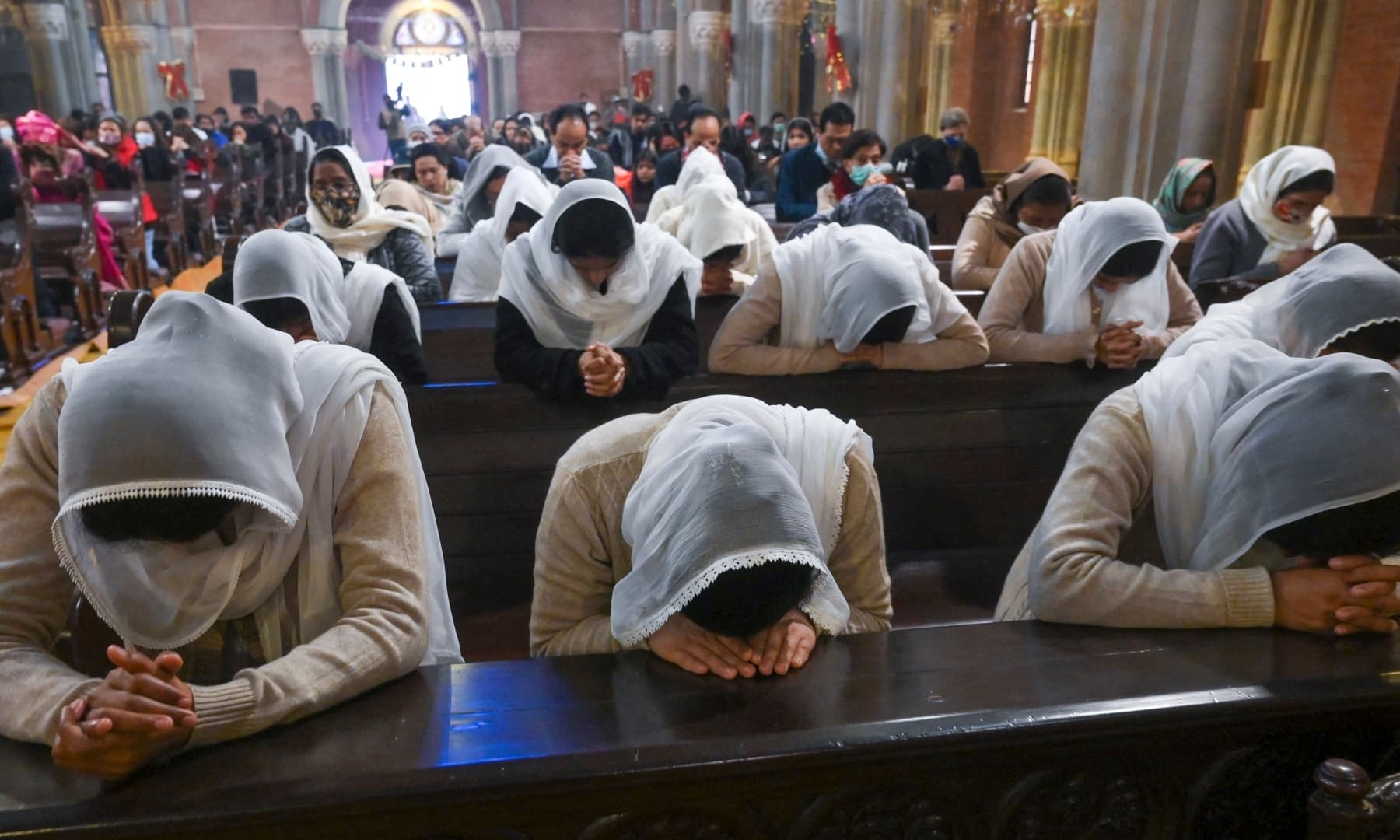 Christian devotees attend a prayer service at Sacred Heart Cathedral to celebrate Christmas in Lahore on December 25, 2021. — AFP