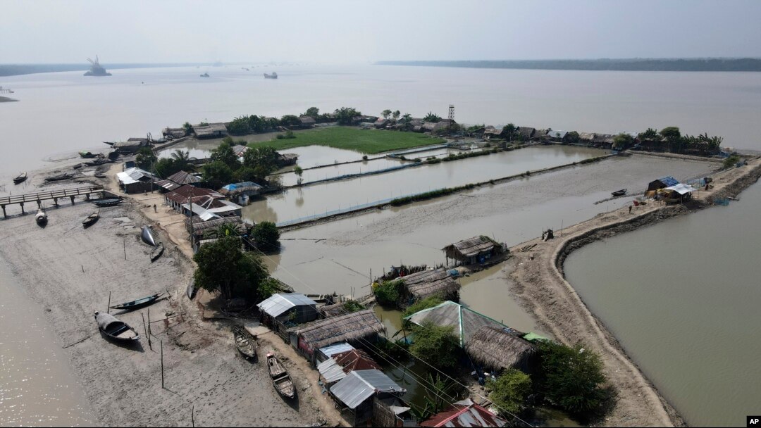 Boats sit near homes in the Sundarbans, the world’s largest mangrove forest, near the Maitree Super Thermal Power Project in Rampal, Bangladesh, Tuesday, Oct. 18, 2022. (AP Photo/Al-emrun Garjon)