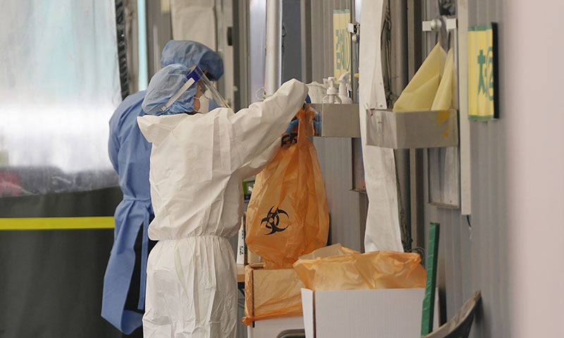 Health workers wearing protective gear prepare for visitors at a temporary screening clinic for the coronavirus in Seoul, South Korea on Monday. — AP