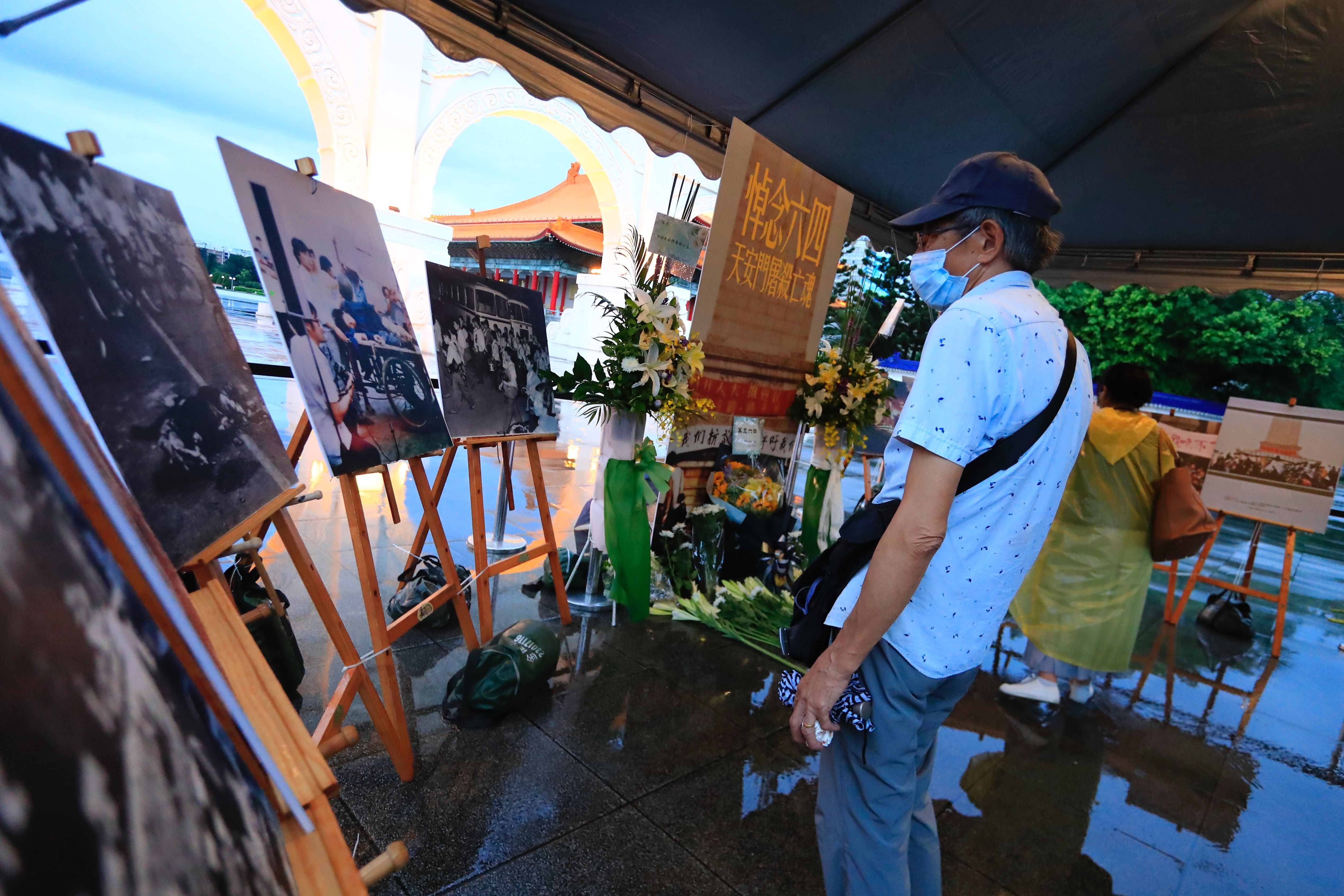 Photo of a person looking at a photo exhibition commemorating the Tiananmen Square Massacre