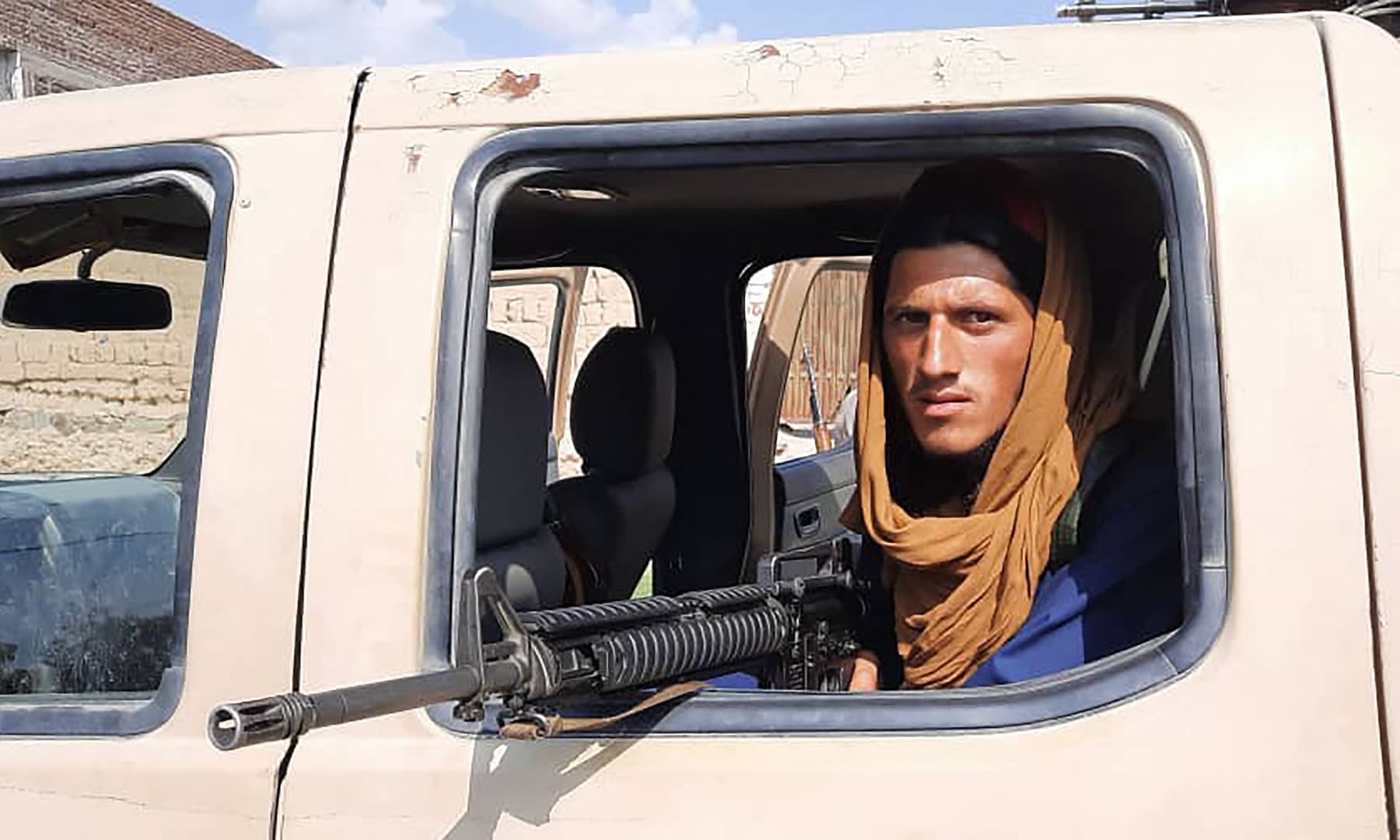 A Taliban fighter sits inside an Afghan National Army vehicle along the roadside in Laghman province, Afghanistan on August 15, 2021. — AFP