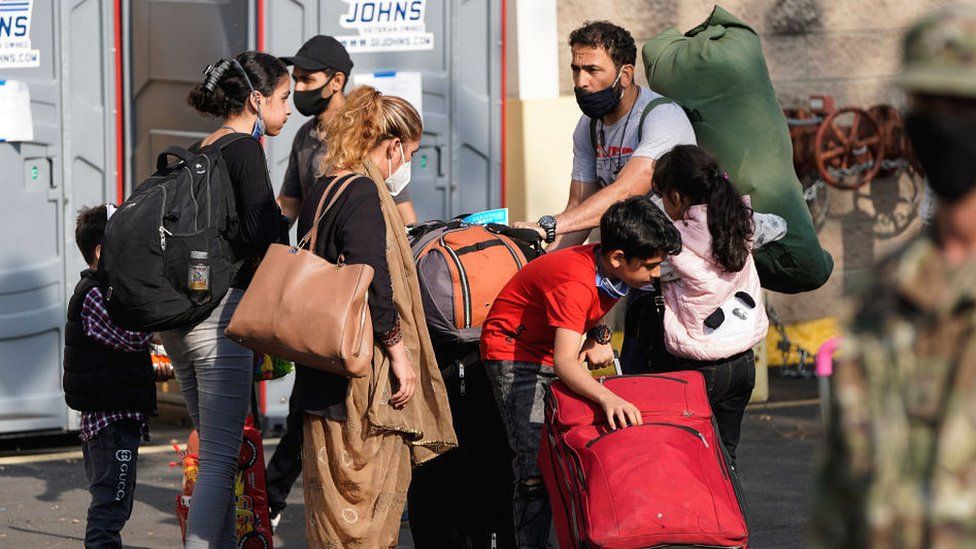 Afghans with luggage at Dulles Expo Center, Virigina