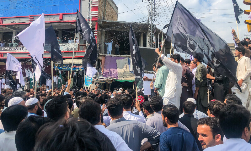 The demonstrators were seen holding white and black flags as they walked through the markets of the district. — Photo by author