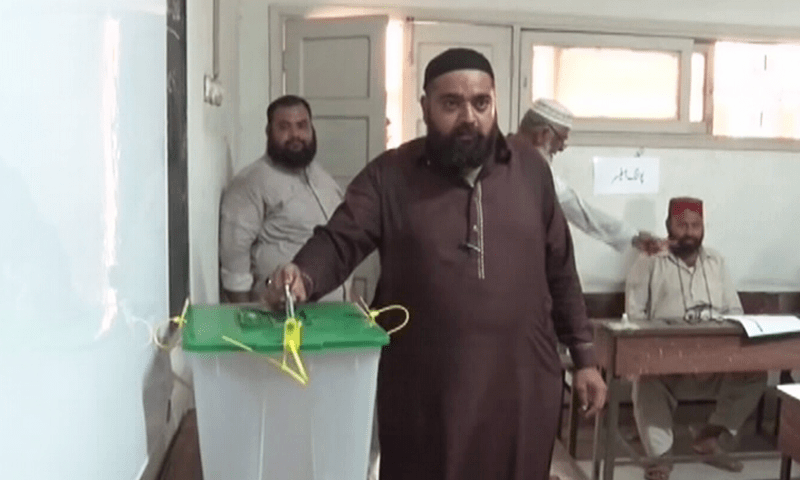 A man puts his vote in the ballot box during the by-election in the NA-245 constituency on Sunday.—DawnNewsTV