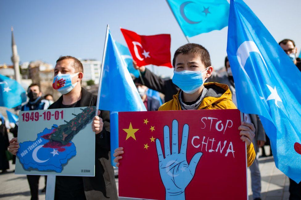 Members of the Muslim Uighur minority hold placards as they demonstrate to ask for news of their relatives and to express their concern about the ratification of an extradition treaty between China and Turkey at Uskudar square in Istanbul on February 26, 2021.