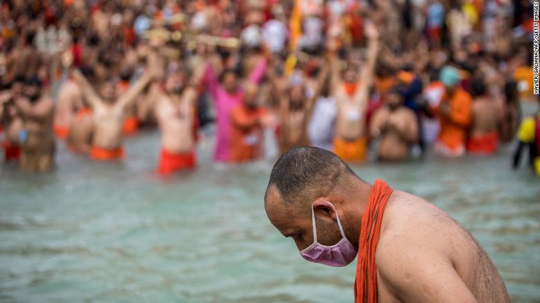 A Sadhu wearing a face mask takes a holy dip in the Ganges River during the Kumbh Mela festival in Haridwar, India, on April 12.