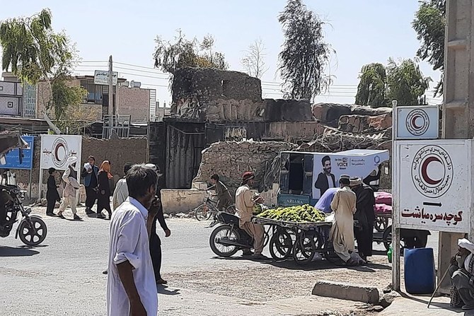 Afghan men walk along a road in Zaranj on August 7, 2021 after Taliban captured their first provincial capital since launching an offensive to coincide with the departure of foreign troops. (AFP)