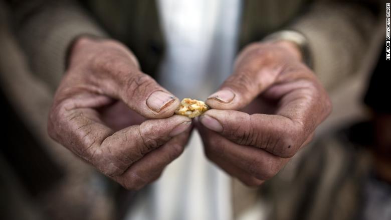 An Afghan man holds a small piece of gold, prospected from the site of a proposed Qara Zaghan mine in 2011.