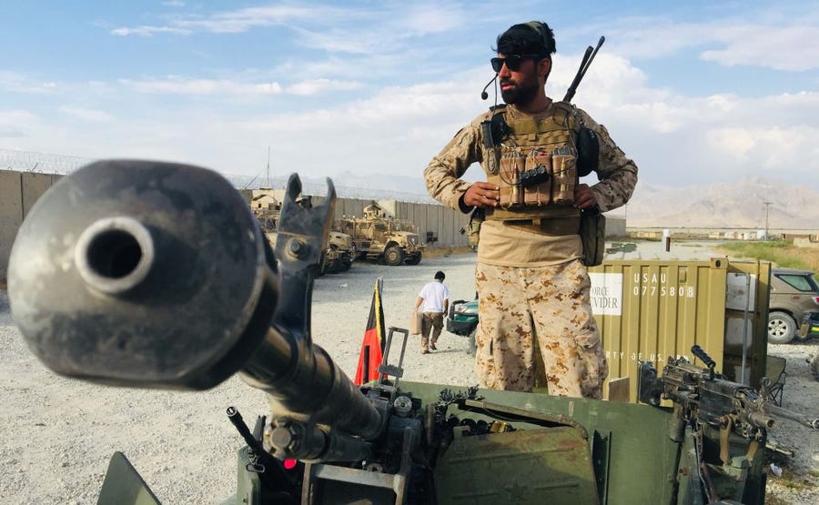 An Afghan soldier wearing a headset stands next to equipment at Bagram.