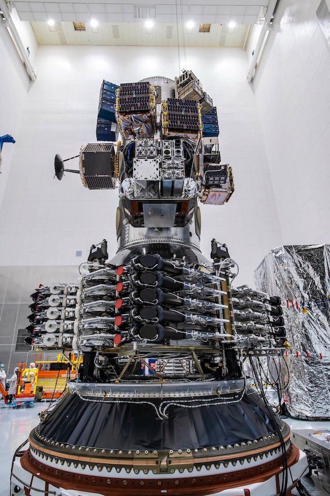 SpaceX lasers: A tower of technical parts and machinery, colored mostly black and silver, sits in a white room.