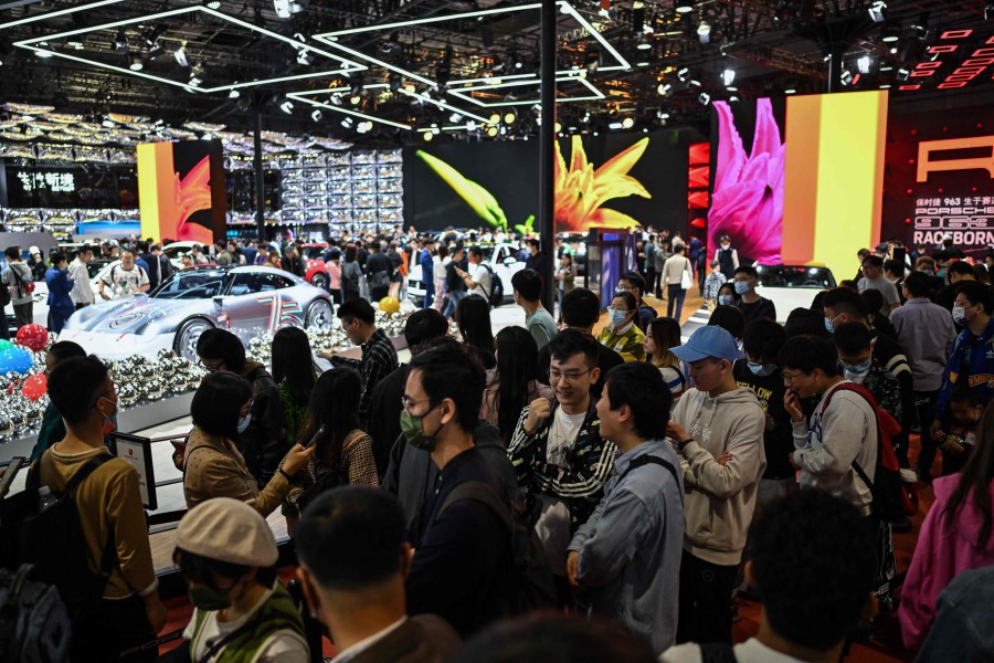 People wait in a line to visit the Porsche booth during the 20th Shanghai International Automobile Industry Exhibition in Shanghai. - AFP PIC