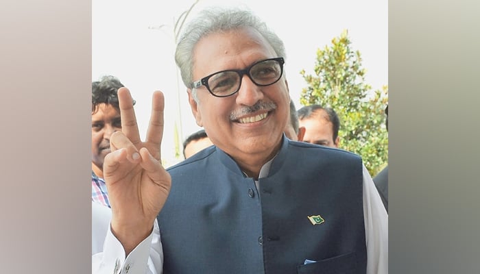 President Dr Arif Alvi smiles as he arrives at Parliament House. —AFP/File