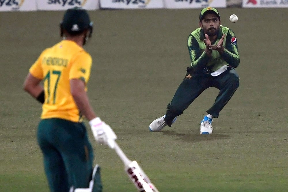 Pakistan's captain Babar Azam (R) takes a catch of South Africa's Jon-Jon Smuts (not pictured) during the second T20 international cricket match between Pakistan and South Africa at the Gaddafi Cricket Stadium in Lahore on February 13. — AFP