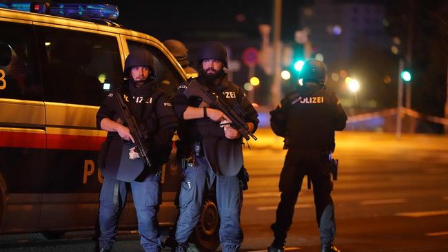 Police cars and armed police officers patrol in central Vienna following the shooting near the synagogue.