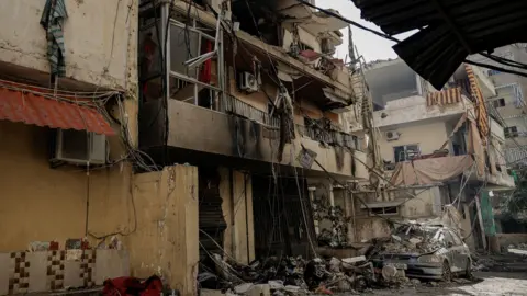 Reuters A damaged vehicle lies amid  rubble after an air strike in the Chiyah area of Dahieh. 