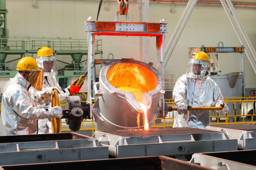 Workers in a modern foundry pouring metal into sand molds