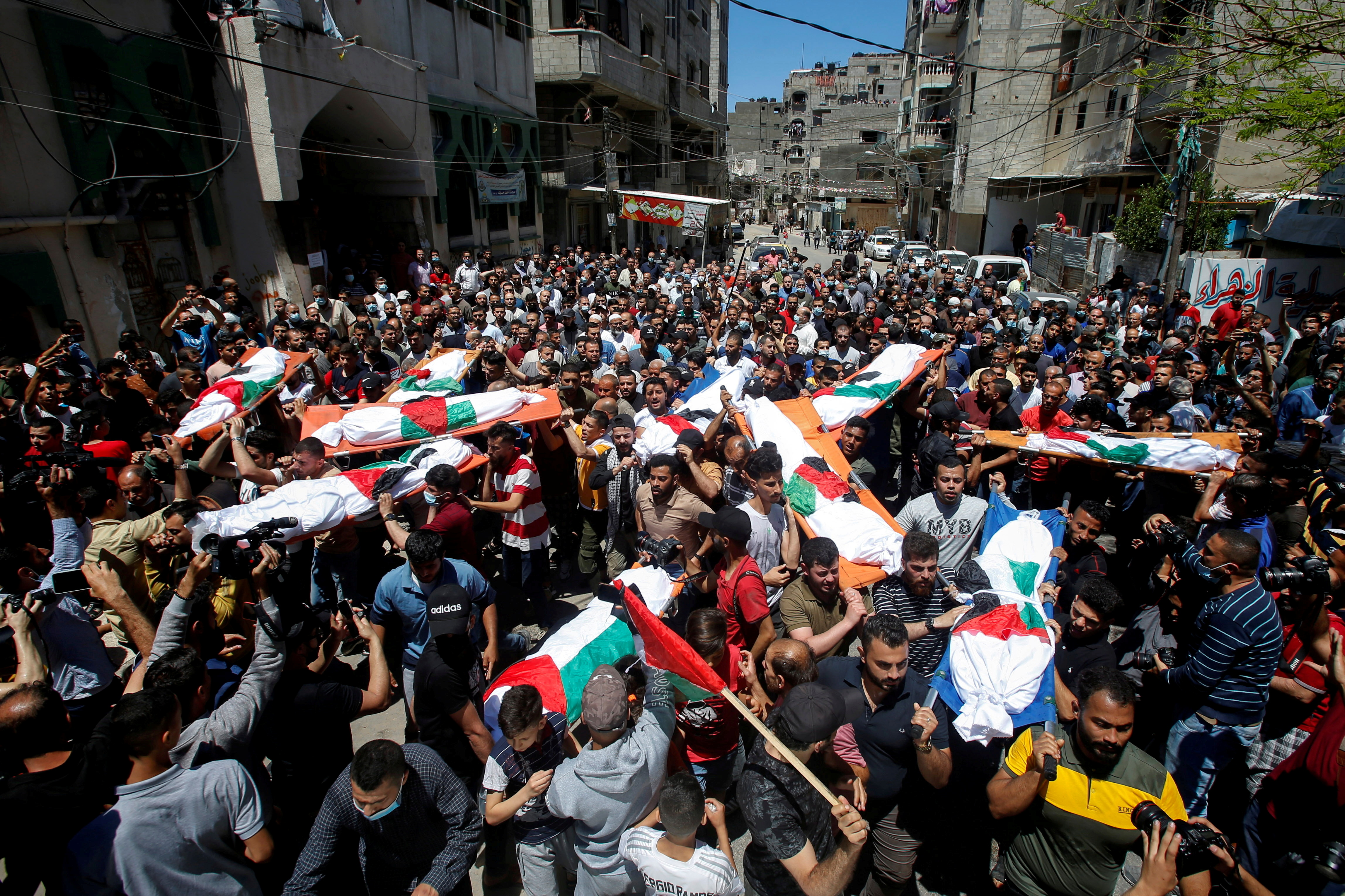 Mourners carry the bodies of Palestinians, including members of Abu Hatab family, who were killed amid a flare-up of Israeli-Palestinian violence, during their funeral at the Beach refugee camp, in Gaza City May 15, 2021. REUTERS/Mohammed Salem  