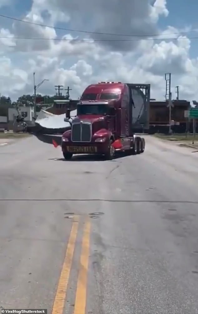 The driver recording the footage began shouting expletives and 'Oh my God' as the train blared its horn at Canup's semi