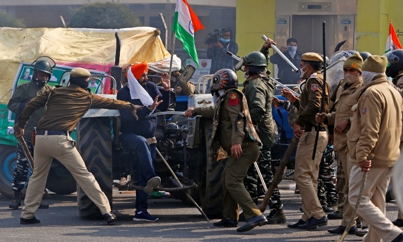 Police officers scuffle with a demonstrator during a protest against farm laws introduced by the government, in New Delhi, India, January 26. — Reuters