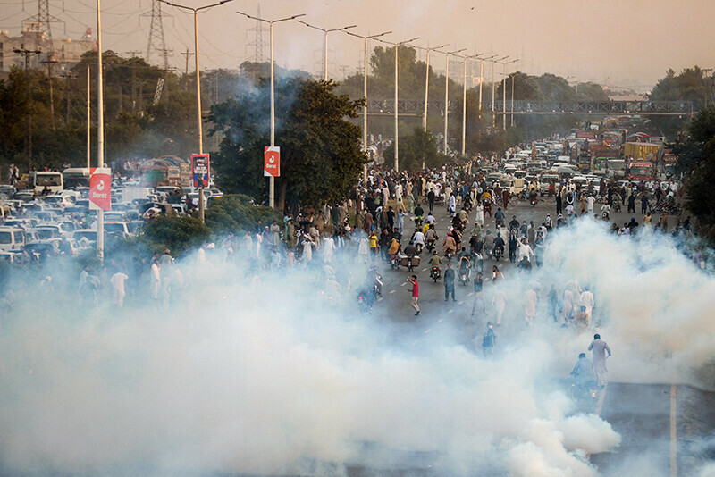 Protesting supporters of PTI are seen in Islamabad amid tear gas smoke used to disperse them, after the ECP disqualified Imran Khan on Friday.—Reuters/Waseem Khan