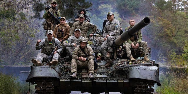 Ukrainian troops ride upon a repaired Russian tank in a wooded area outside the city on Sept. 26 2022, in Kharkiv, Ukraine.