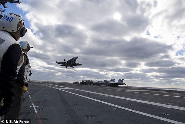 A fighter jet is seen landing on the USS Ford in November 2020. The carrier's take off and landing systems' failure rate was 'well below the requirement'