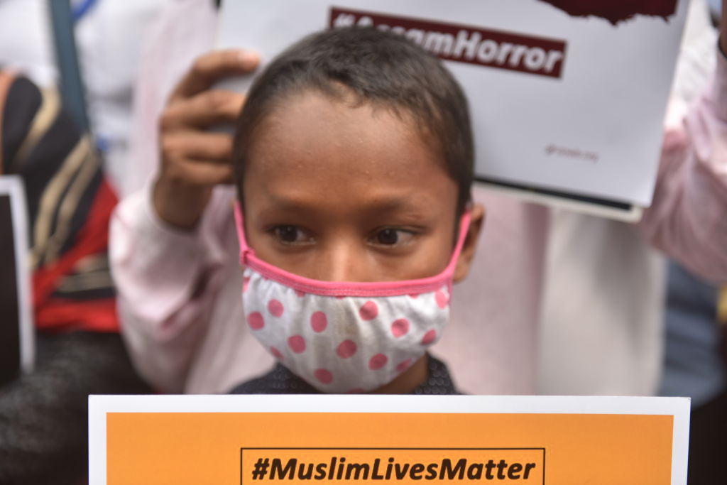 A boy holds a placard during a massive protest  in Kolkata, India on Sept. 25 against the killing of two Muslims in Assam. (Sukhomoy Sen/NurPhoto via Getty Images)