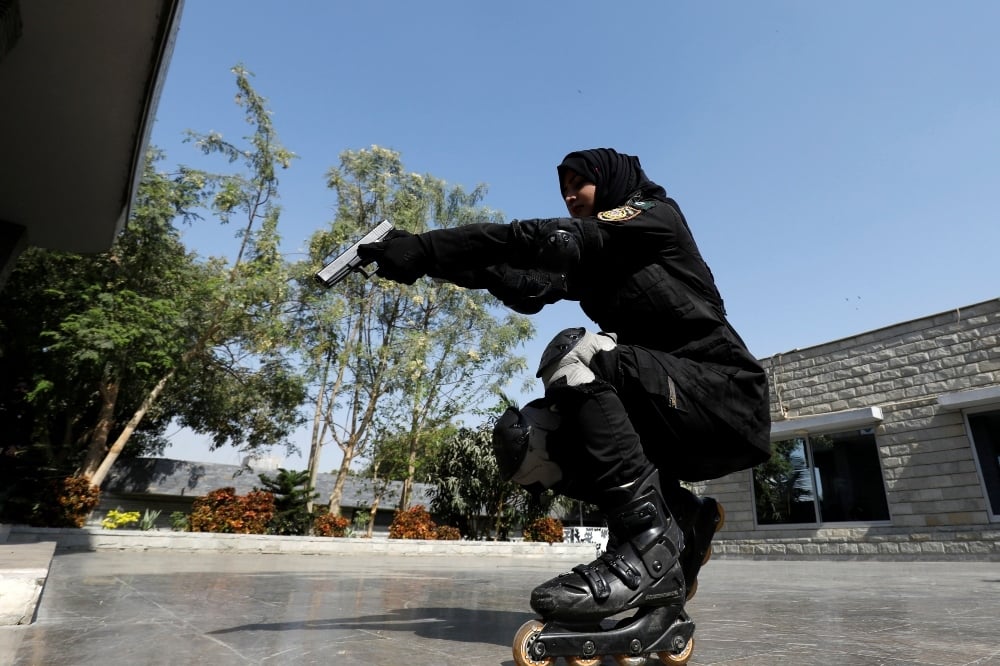 A Special Security Unit (SSU) police member holds up her weapon as she rollerblades during practice at the headquarters in Karachi on Feb 18. - Reuters