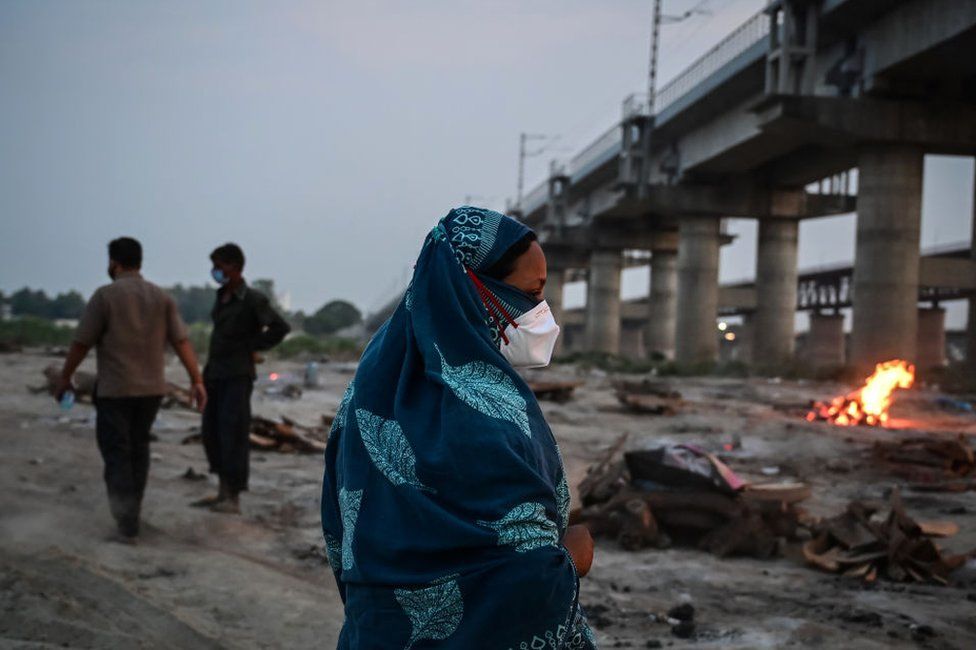 Relatives walk away from bodies of Covid-19 victims being cremated on the banks of the Ganges river May 06, 2021 in Allahabad, Uttar Pradesh, India.