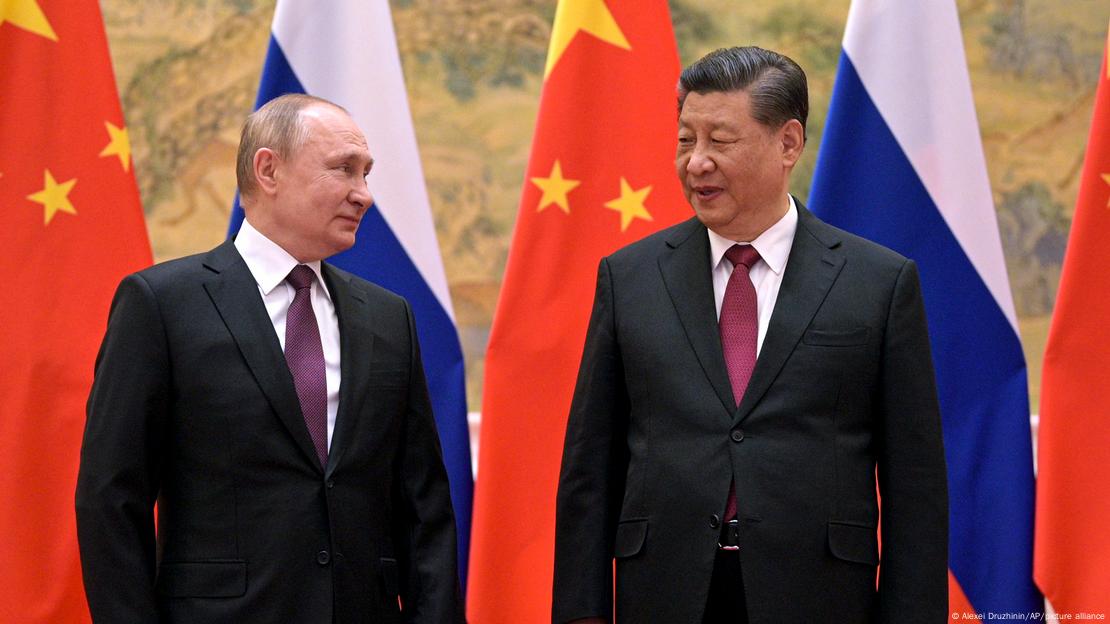 Vladimir Putin and Chinese President Xi Jinping, their flags behind them