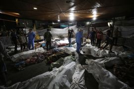 Bodies of Palestinians killed in the explosion at al-Ahli Arab Hospital are gathered in the front yard of al-Shifa Hospital in Gaza City [File: Abed Khaled/AP]