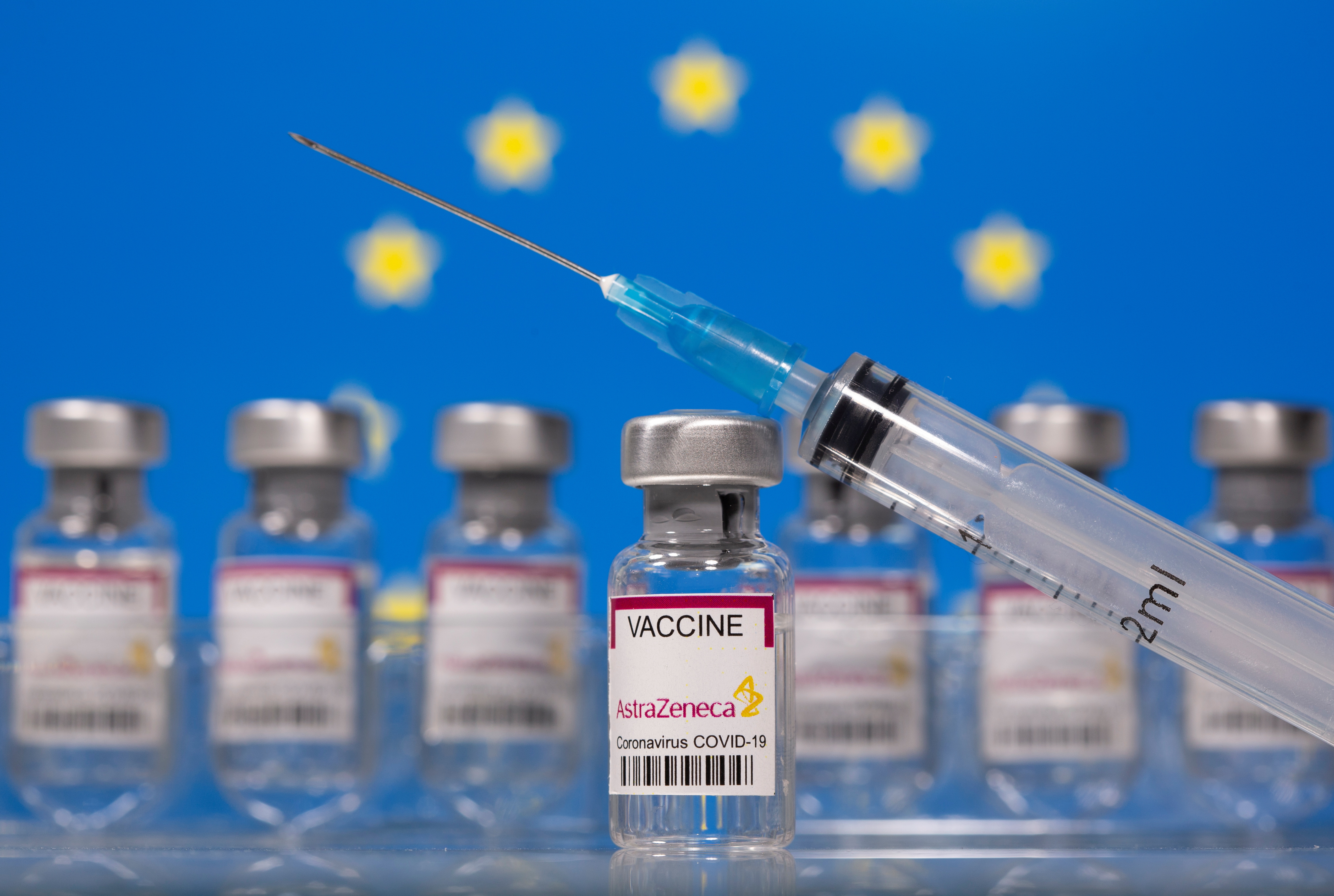 Vials labelled Astra Zeneca COVID-19 Coronavirus Vaccine and a syringe are seen in front of a displayed EU flag in this illustration taken March 10, 2021. REUTERS/Dado Ruvic/Illustration