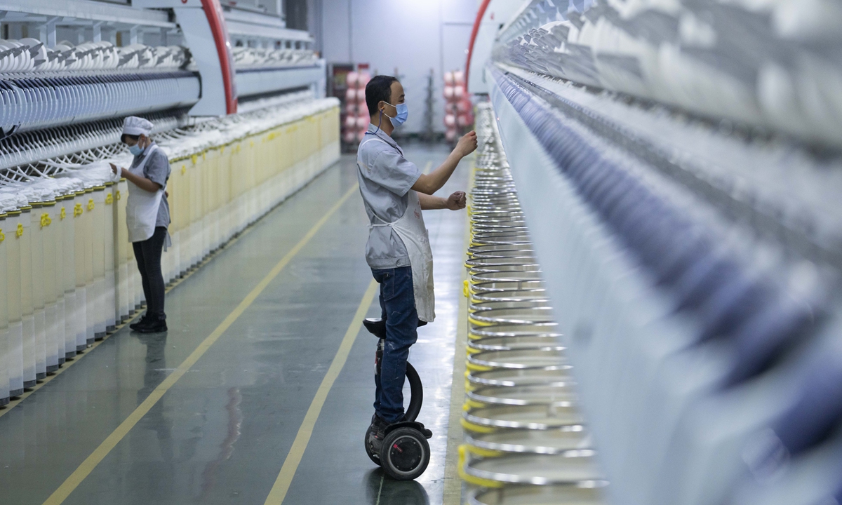 An employee works at an air spinning workshop in Xinjiang on January 1, 2021. Photo: cnsphoto